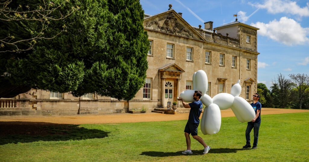 A Swindog being carried in front of stately home on a sunny day.